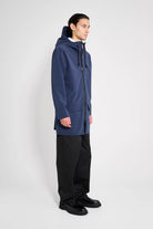 Stockholm Patch Navy Raincoat worn by a model showcasing its oversized fit and adjustable drawstring hood.