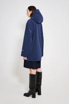 Stockholm Patch Navy Raincoat displayed on a model showcasing its oversized fit and adjustable drawstring hood.