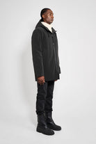 Stockholm Matte Black Winter Coat worn by a model showcasing its oversized unisex design and adjustable hood.