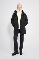 Stockholm Matte Black Winter Coat modeled by a person wearing a cozy sweater and dark jeans.