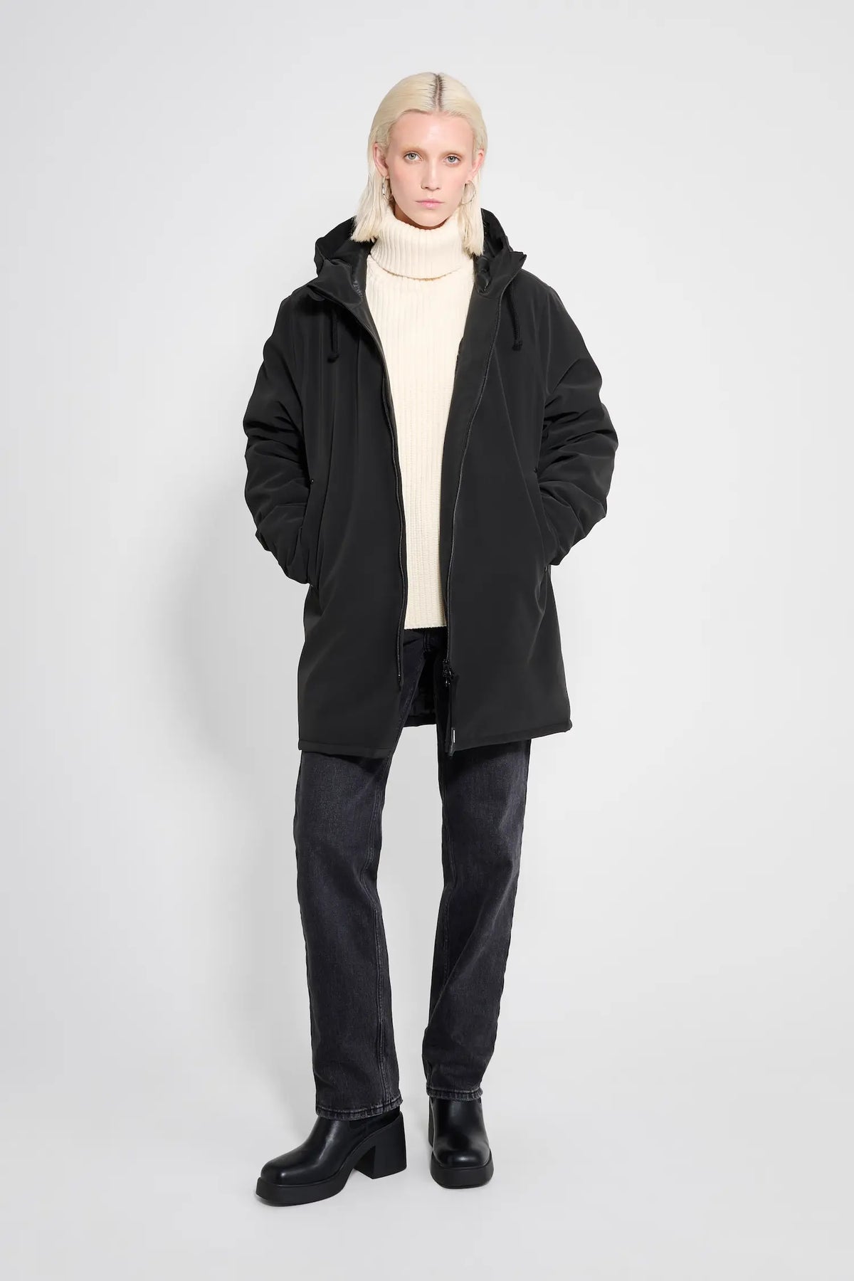 Stockholm Matte Black Winter Coat modeled by a person wearing a cozy sweater and dark jeans.