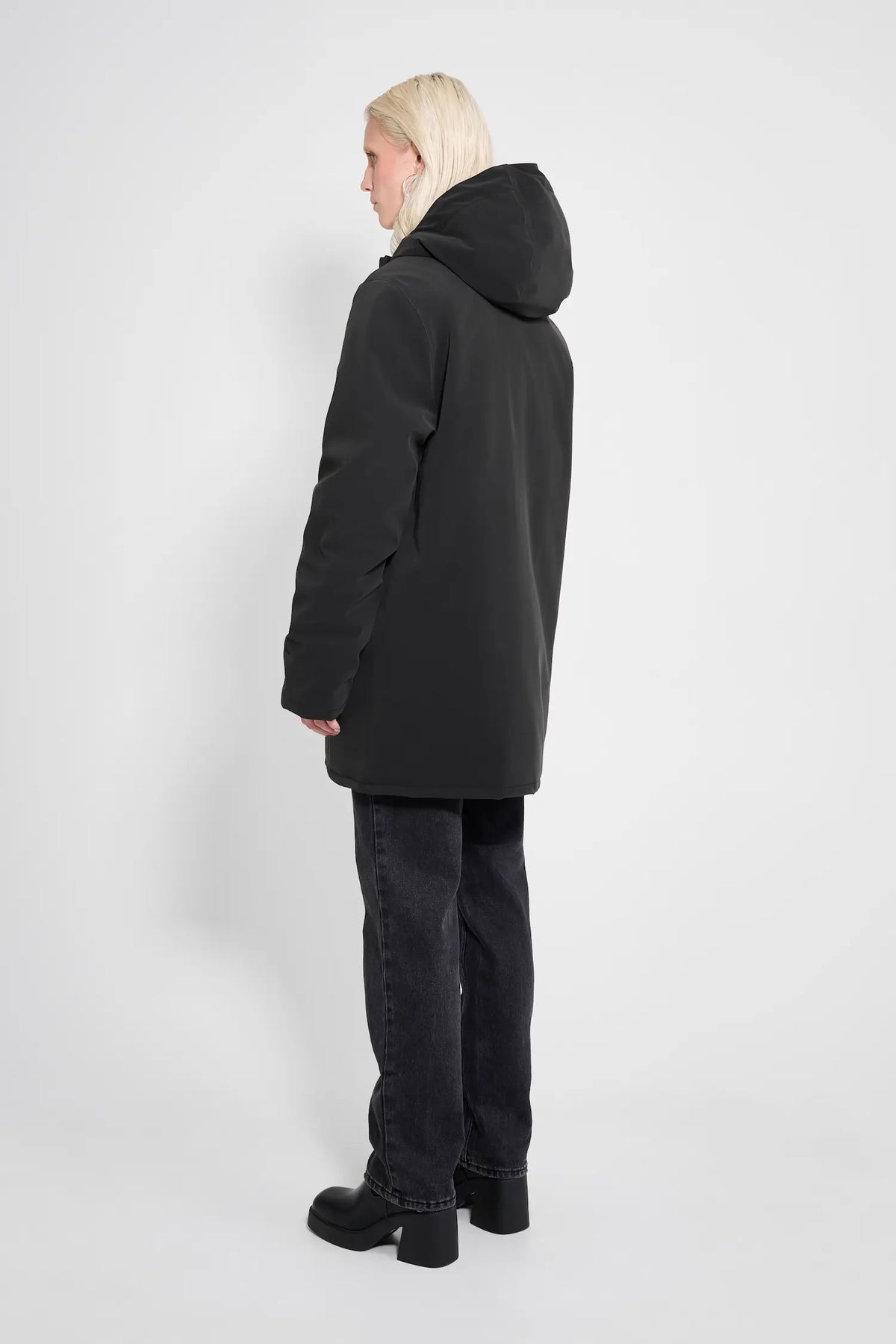Stockholm Matte Black Winter Coat worn from the back, showcasing its oversized fit and adjustable hood.