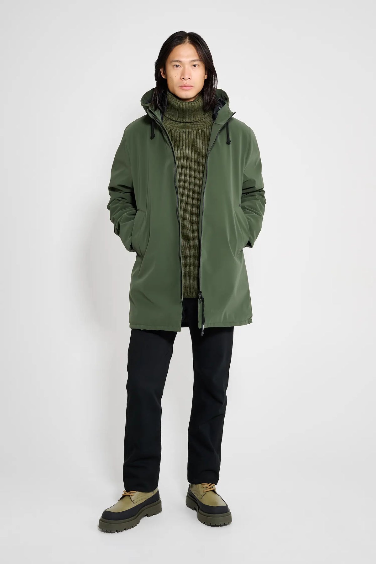 Model wearing the Stockholm Matte Green Winter Coat with a turtleneck and pants.