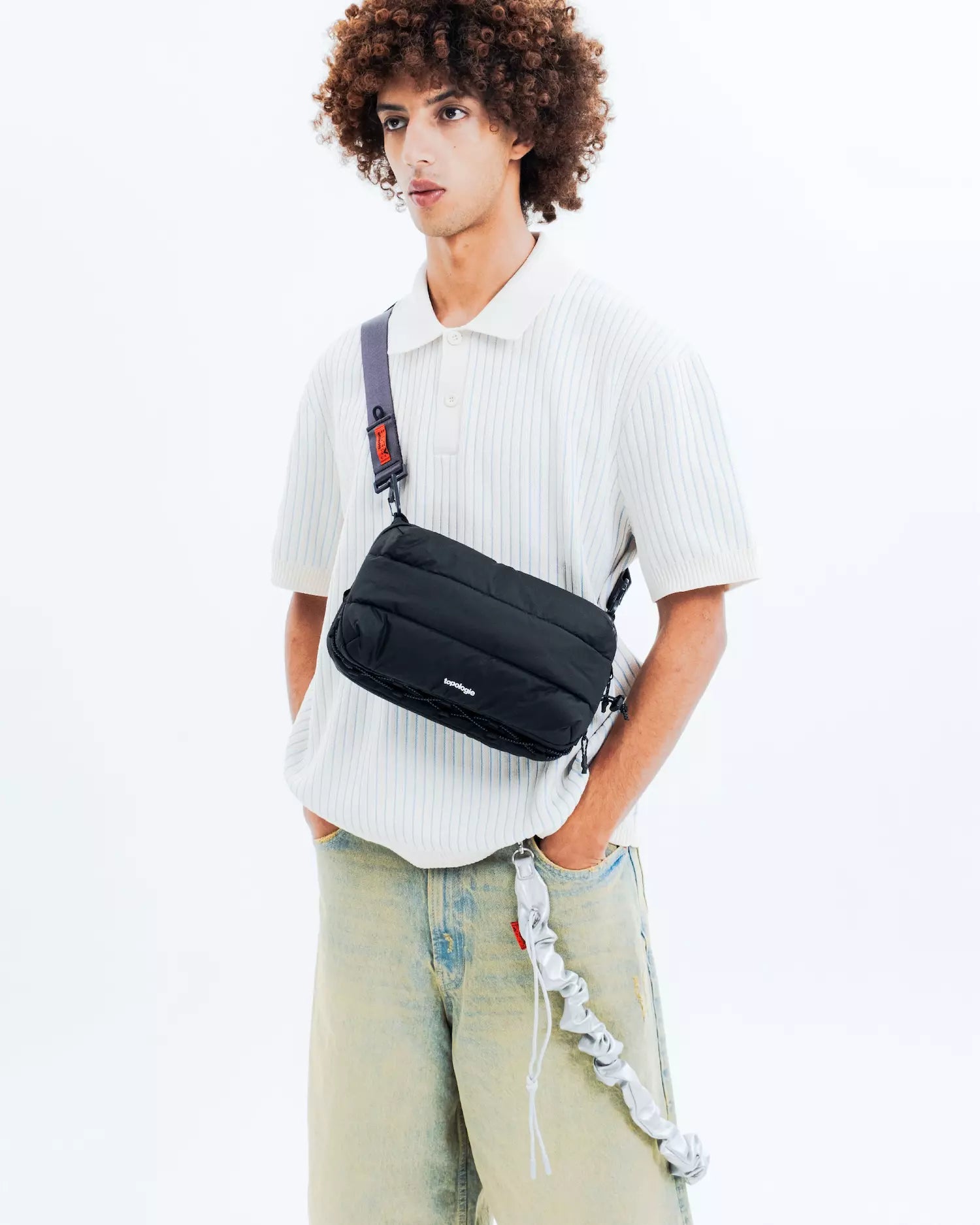 Bottle Sacoche Large Black Silky Peach Bag being worn by a model in casual attire, showcasing its versatile design.