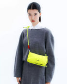 Bottle Sacoche Medium Purple Washed Silk Nylon Bag shown on a model with a grey outfit and a vibrant yellow strap.