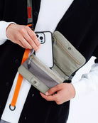 Phone Sacoche 90 Purple Washed Silk Nylon Bag with phone in hand showing compartments and strap.