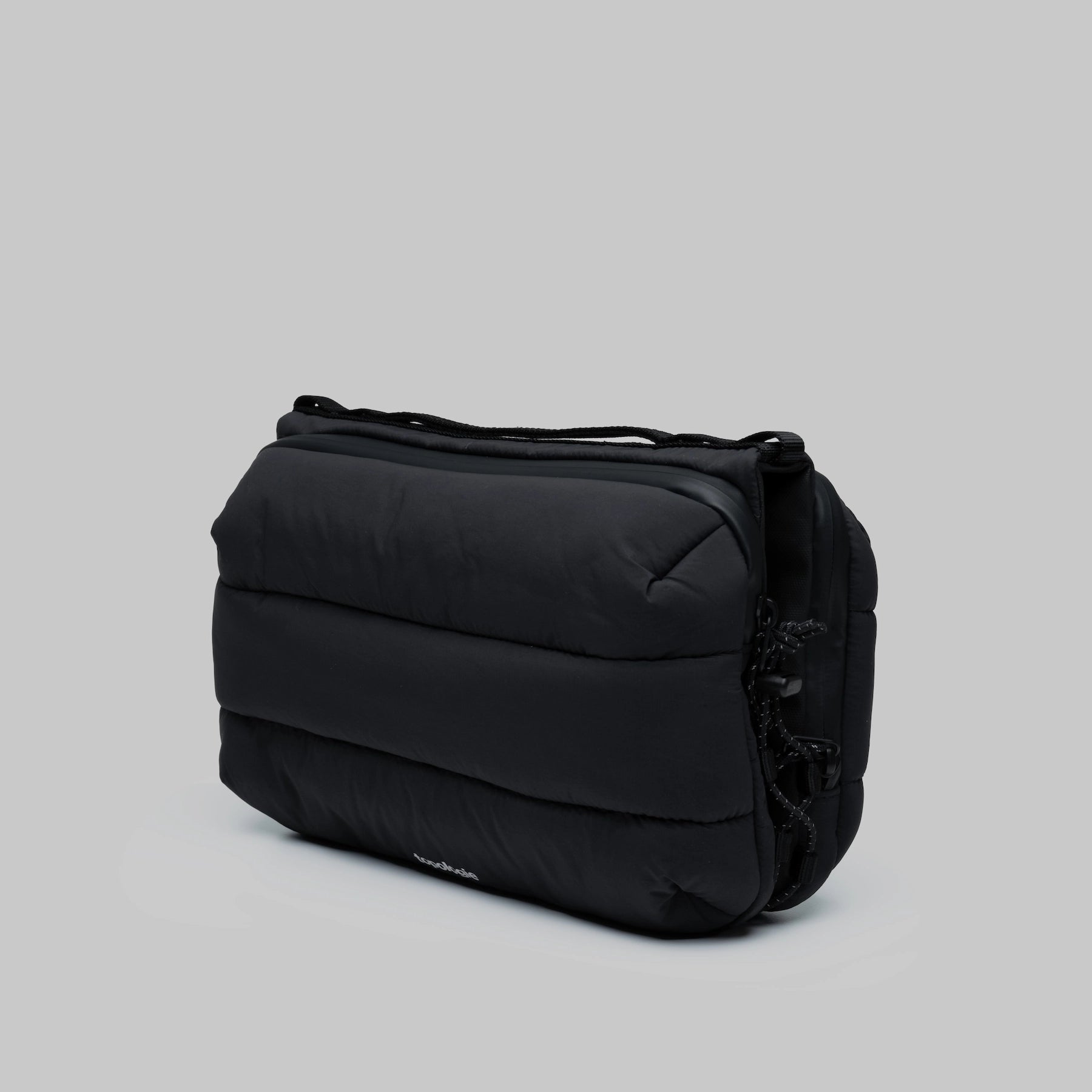 Bottle Sacoche Large Black Silky Peach Bag in black, showing its stylish padded design and compartments.