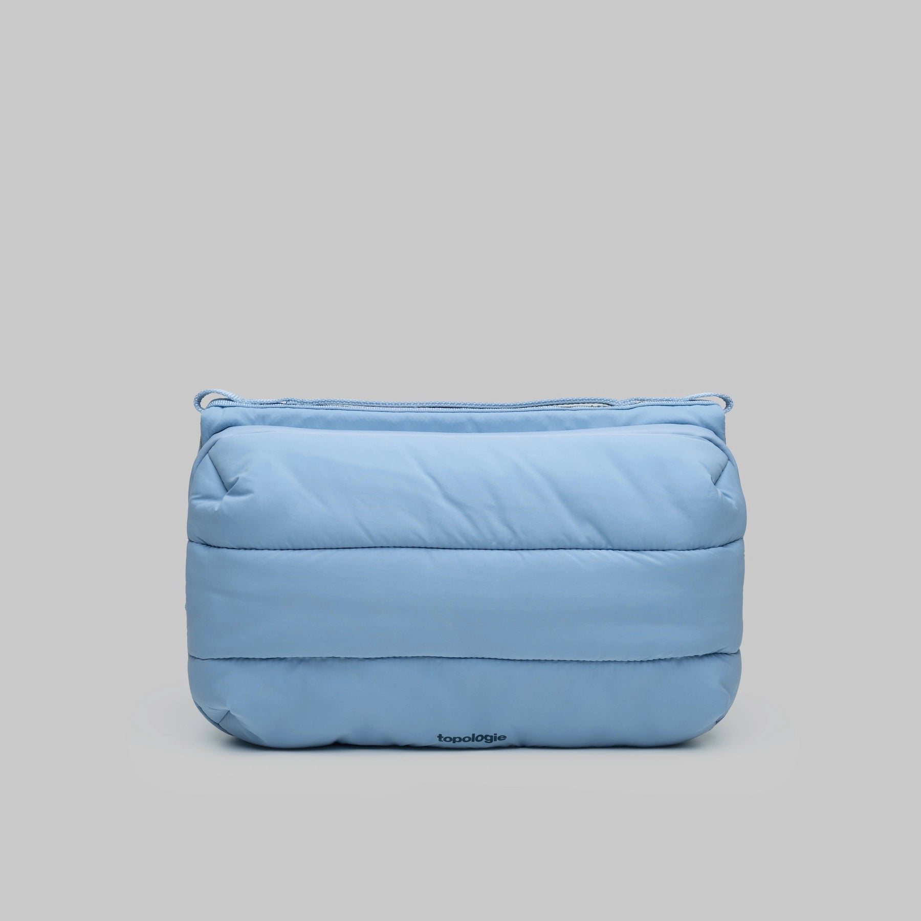 Bottle Sacoche Large Chambray Silky Peach Bag in light blue with puffy design and Topologie logo.