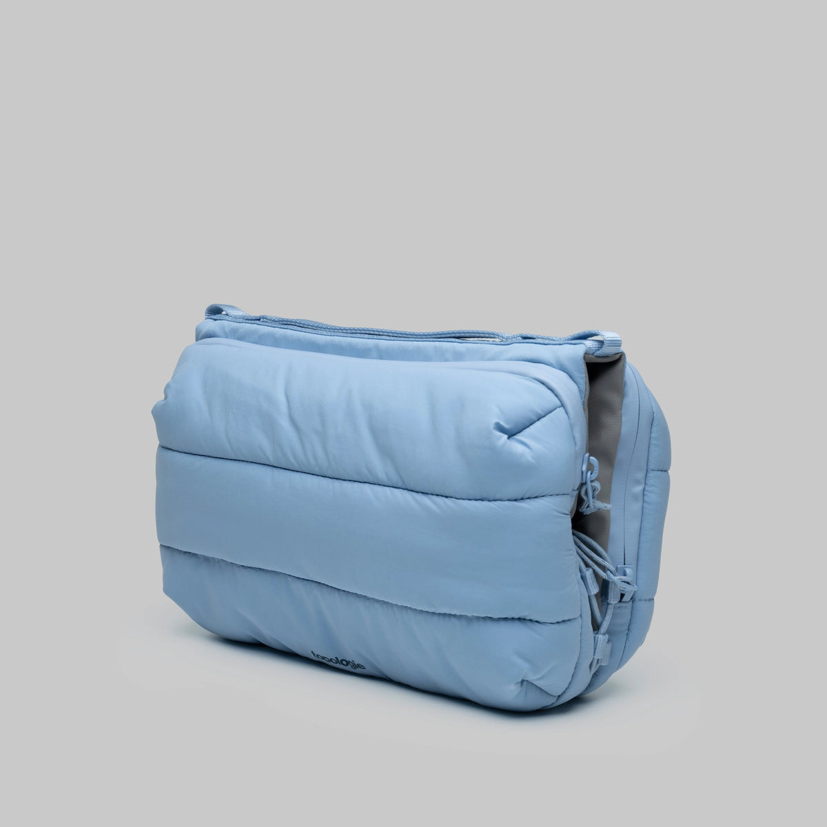 Bottle Sacoche Large Chambray Silky Peach Bag in soft blue color showcasing its zipped compartments and water repellent fabric.