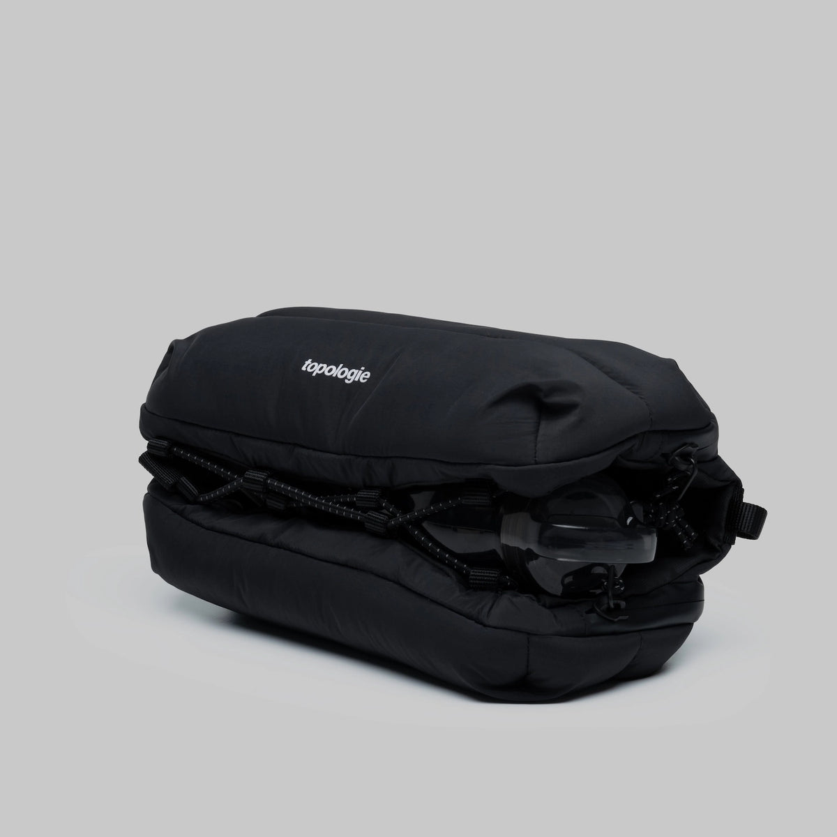 Bottle Sacoche Medium Black Silky Peach Bag in black water repellent fabric, compact design with external cord.
