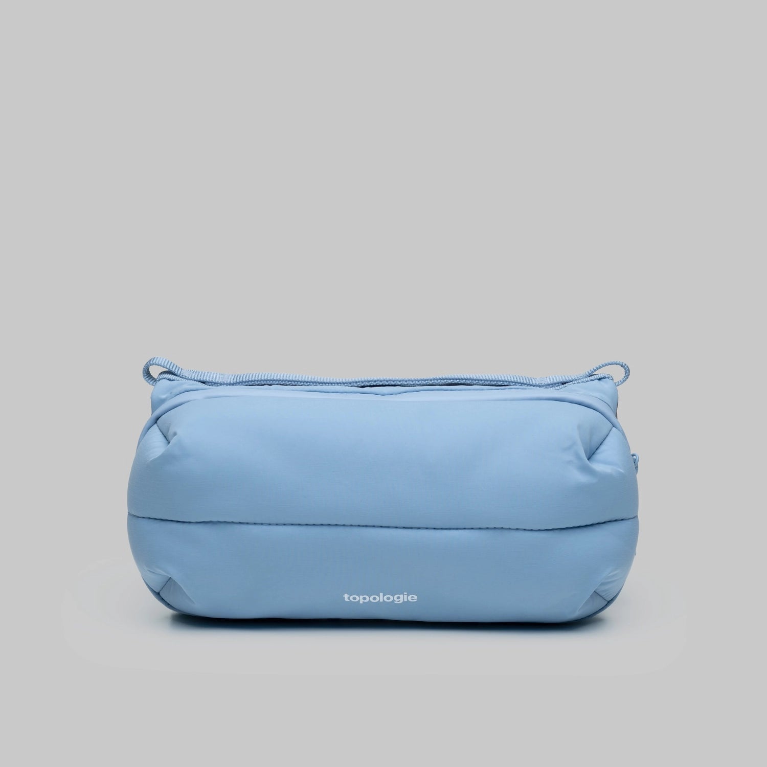 Bottle Sacoche Medium Chambray Silky Peach Bag in a light blue color with a sleek design.