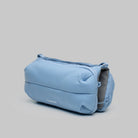 Bottle Sacoche Medium Chambray Silky Peach Bag in light blue, featuring soft fabric and multiple compartments.