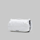 Bottle Sacoche Medium Ecru Matt Coated Bag on a gray background showcasing its water-repellent fabric and sleek design.