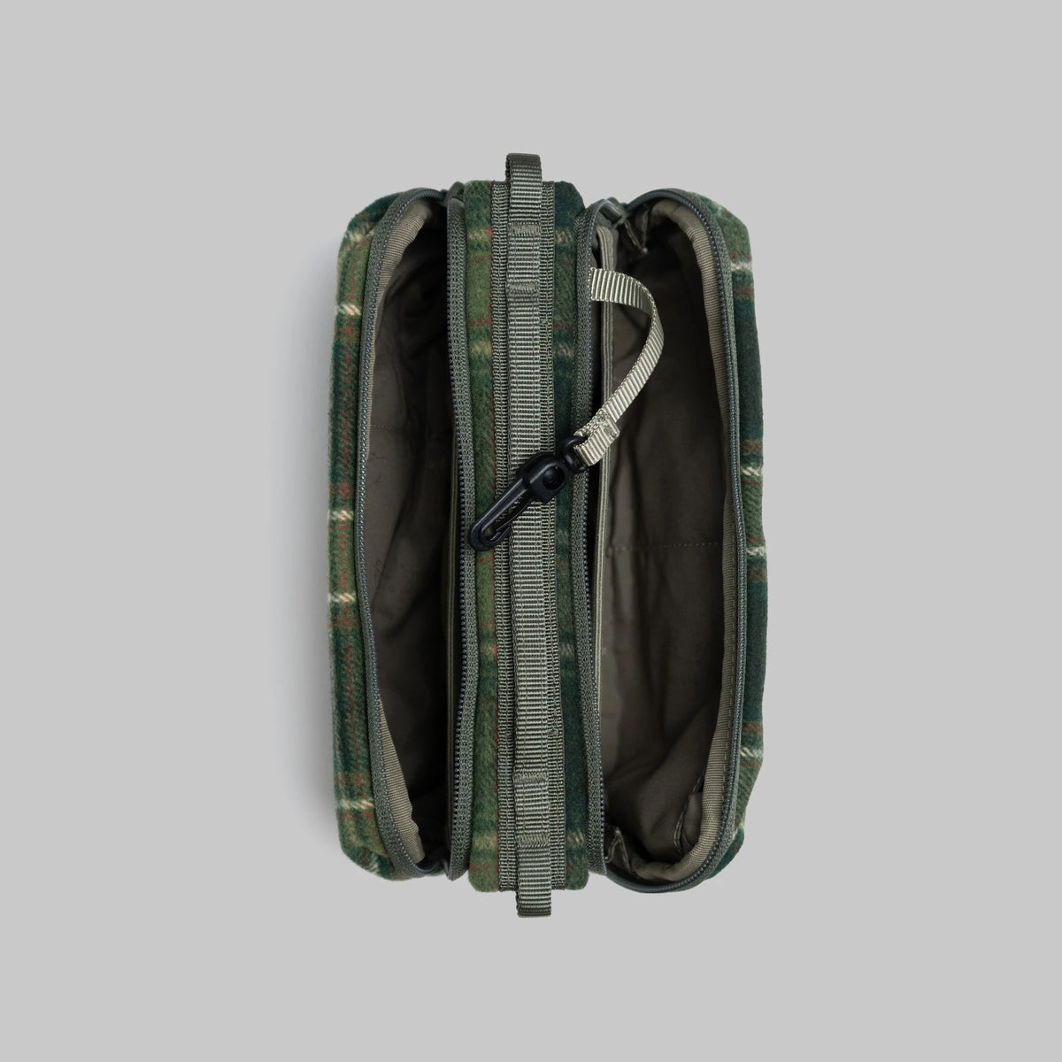 Bottle Sacoche Medium Green Check Wool Bag open showing two main zipped compartments and internal pockets.