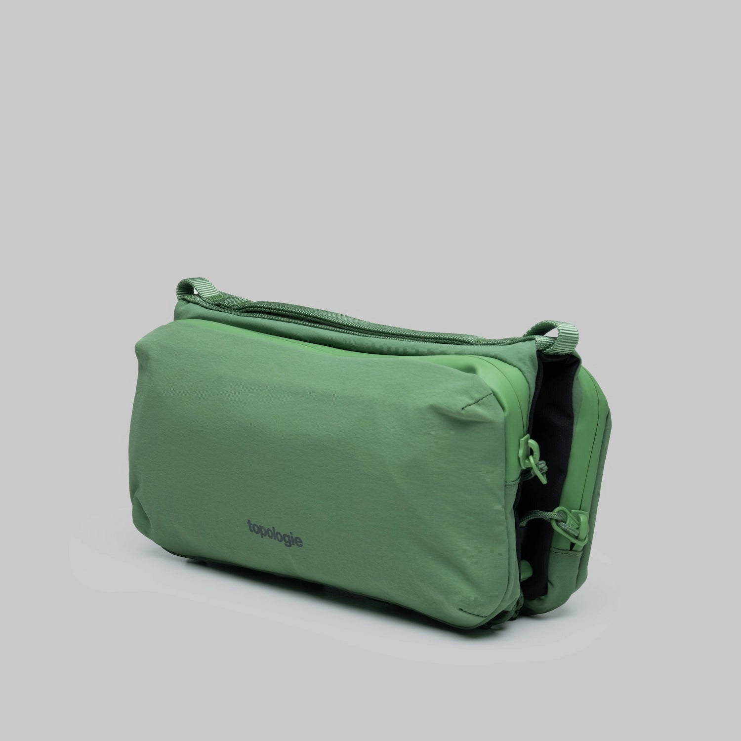 Bottle Sacoche Medium Ivy Green Papery Bag showcasing a water repellent fabric and zippers.