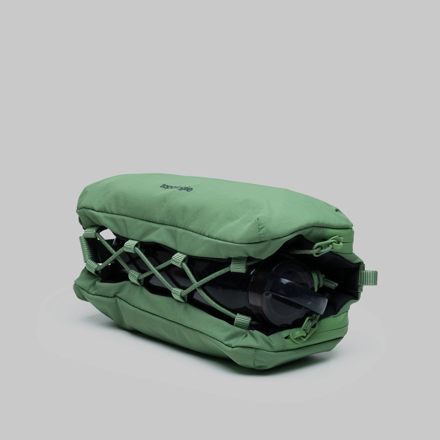 Bottle Sacoche Medium Ivy Green Papery Bag showcasing water repellent fabric and compartment for bottles or umbrellas.
