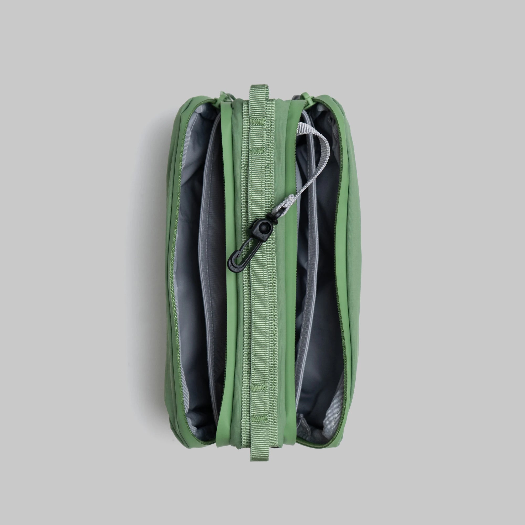 Bottle Sacoche Medium Ivy Green Papery Bag showing internal compartments and zipper details.