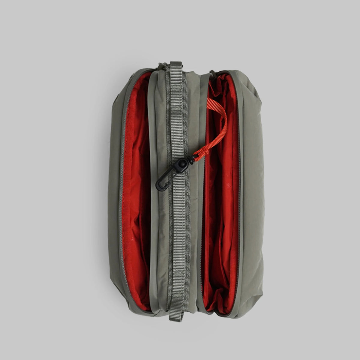 Bottle Sacoche Medium Moss Silky Peach Bag showcasing its compartments and sleek design in grey and red.