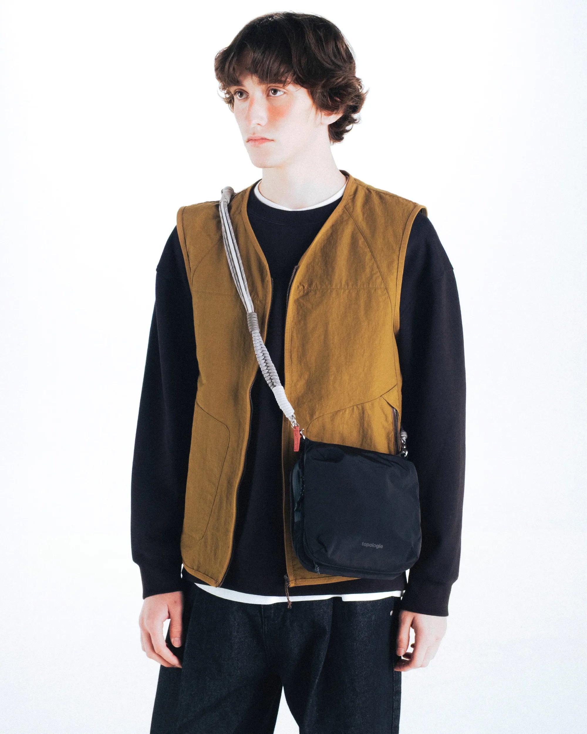 Cassette Sacoche Medium Moss Tech Sateen Bag worn as a crossbody bag by a model in casual outfit.