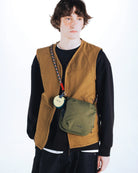 Model wearing a Cassette Sacoche Medium Black Tech Sateen Bag with a crossbody strap.