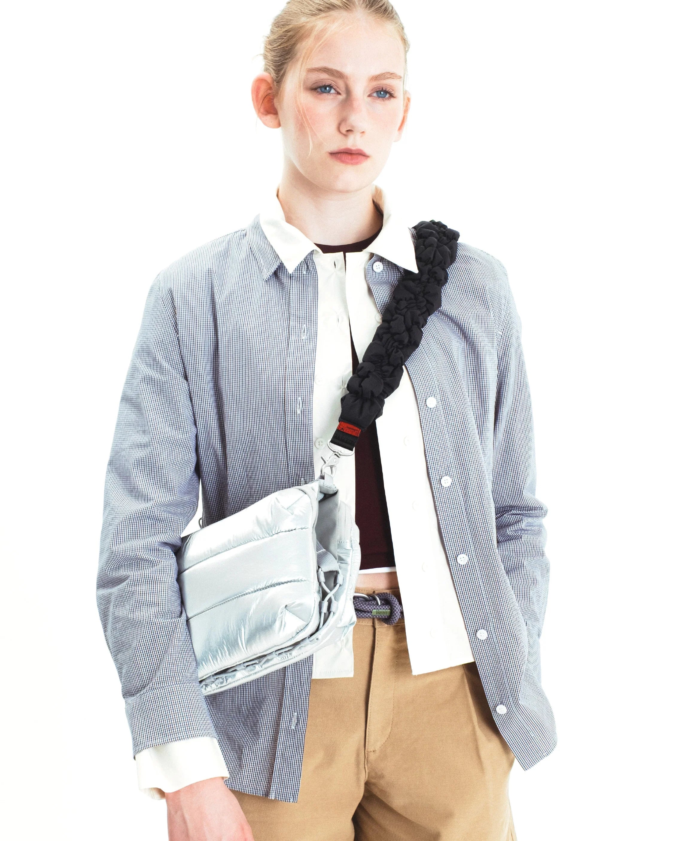 Woman wearing Cloud Strap Black Silky Peach crossbody bag while modeling a stylish outfit.