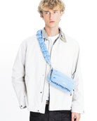 Model wearing Cloud Strap Moss Silky Peach shoulder bag with adjustable strap in blue.