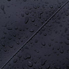 Close-up of water droplets on Kumo Medium Lotus Infinity Dark Navy Backpack, showcasing its waterproof material.