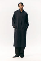 Model wearing Janice B Navy Coat, a lightweight waterproof jacket with a hidden hood and horn buttons.