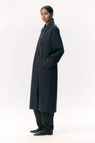 Janice B Navy Coat displayed on a model, showcasing its stylish design and lightweight material.
