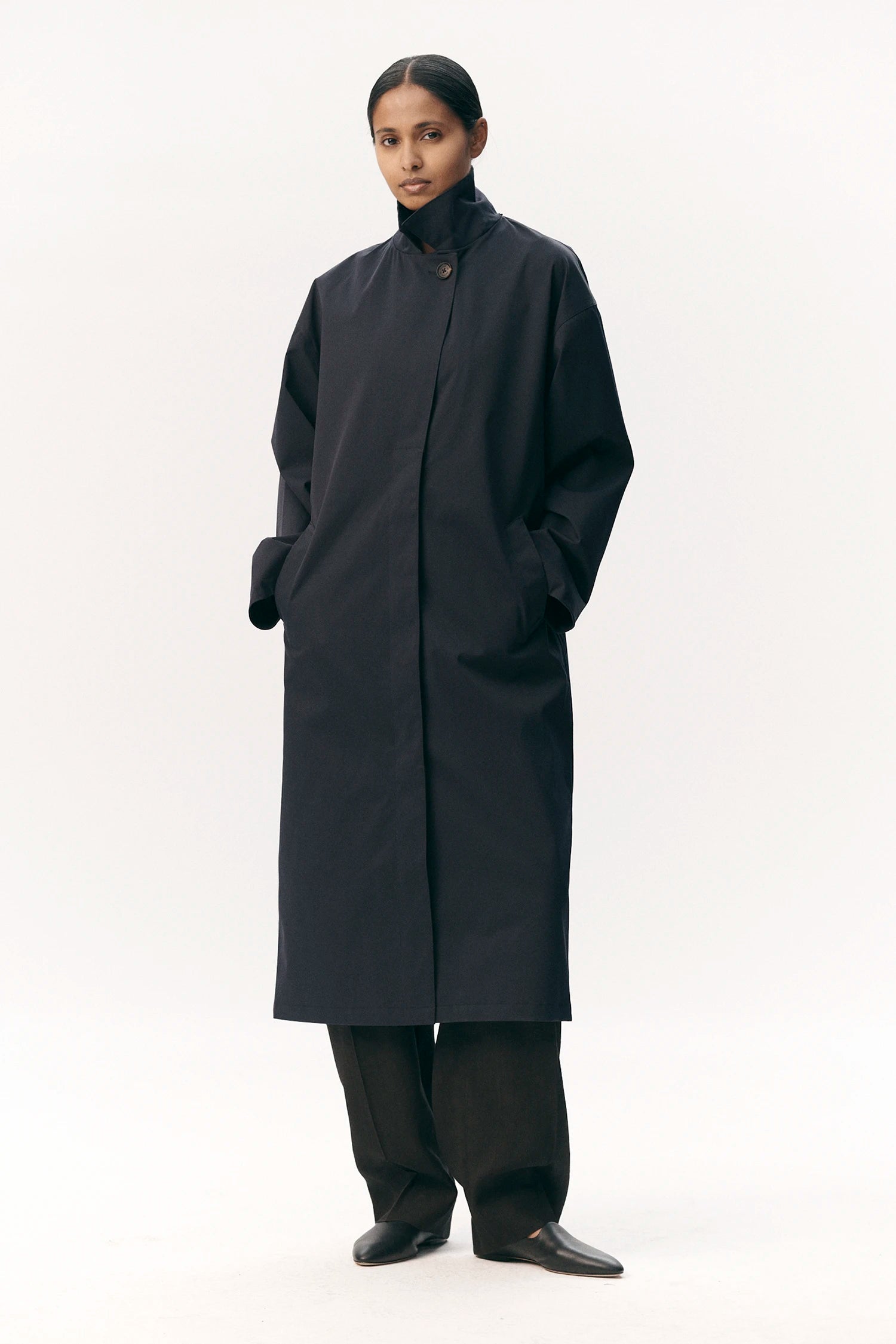 Janice B Navy Coat worn by a model, featuring a sleek design and lightweight waterproof fabric.