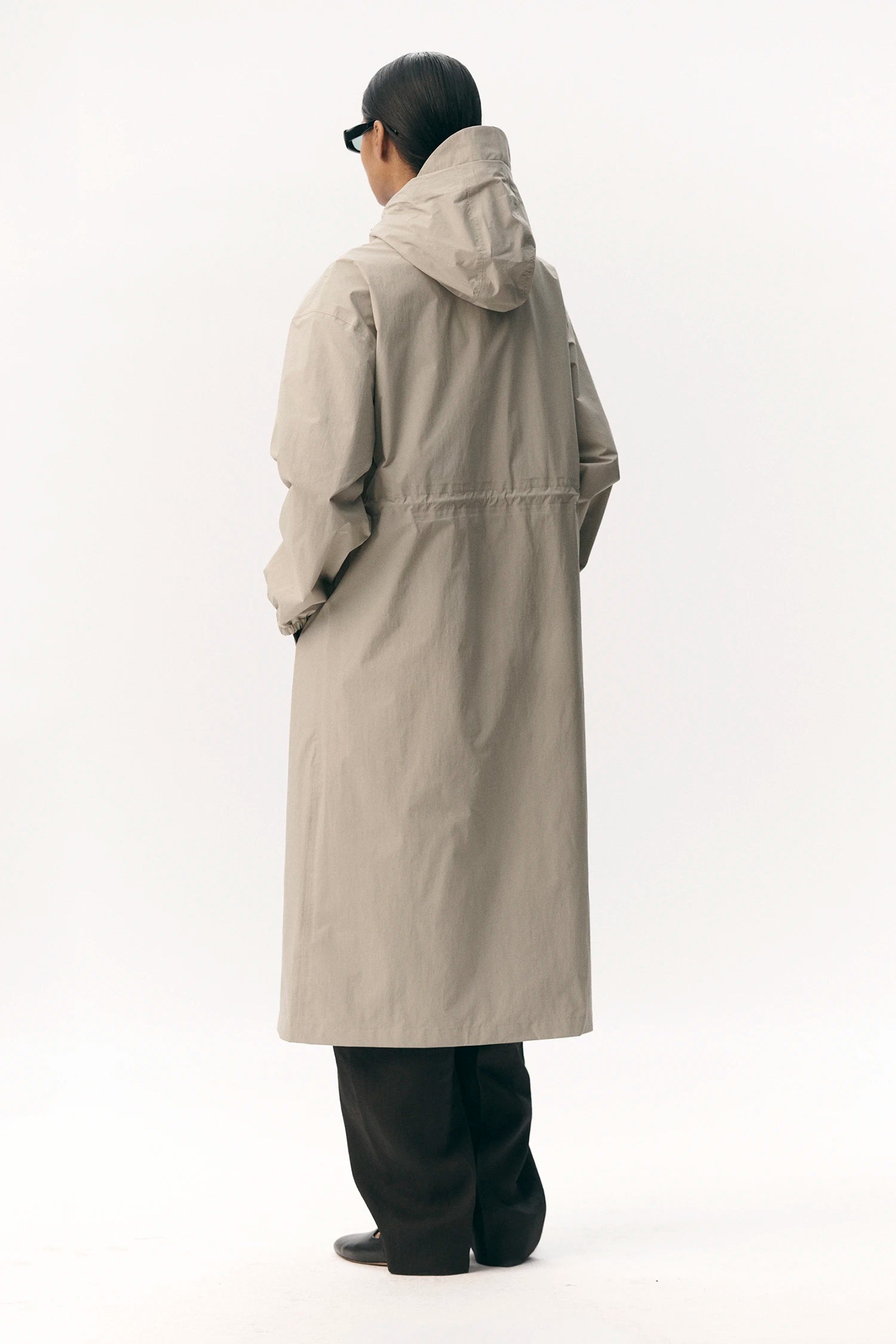 Roomy Long Tube Nylon Light Army Coat worn from the back, showing the adjustable hood and lightweight design.