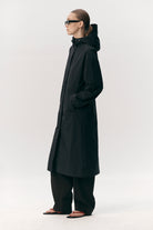 Roomy Long Tube Nylon Navy Coat model wearing waterproof, breathable jacket with adjustable hood and elastic waistband.