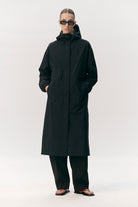 Roomy Long Tube Nylon Navy Coat worn by model, showcasing waterproof design with adjustable hood and sleek style.