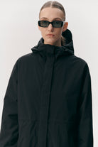 Model wearing a Roomy Long Tube Nylon Navy Coat with sunglasses, showcasing a stylish and functional design.