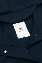 Close-up of the interior label of a Roomy Long Tube Nylon Navy Coat featuring the brand name and size.