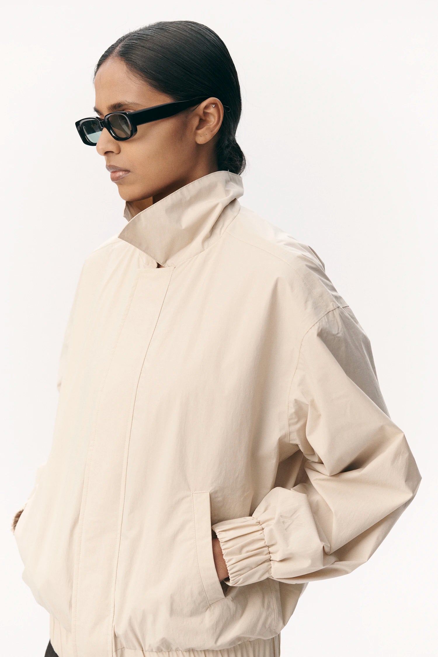 Short Tracker WM Nylon Beige Jacket worn by a model, featuring a roomy fit and lightweight design.