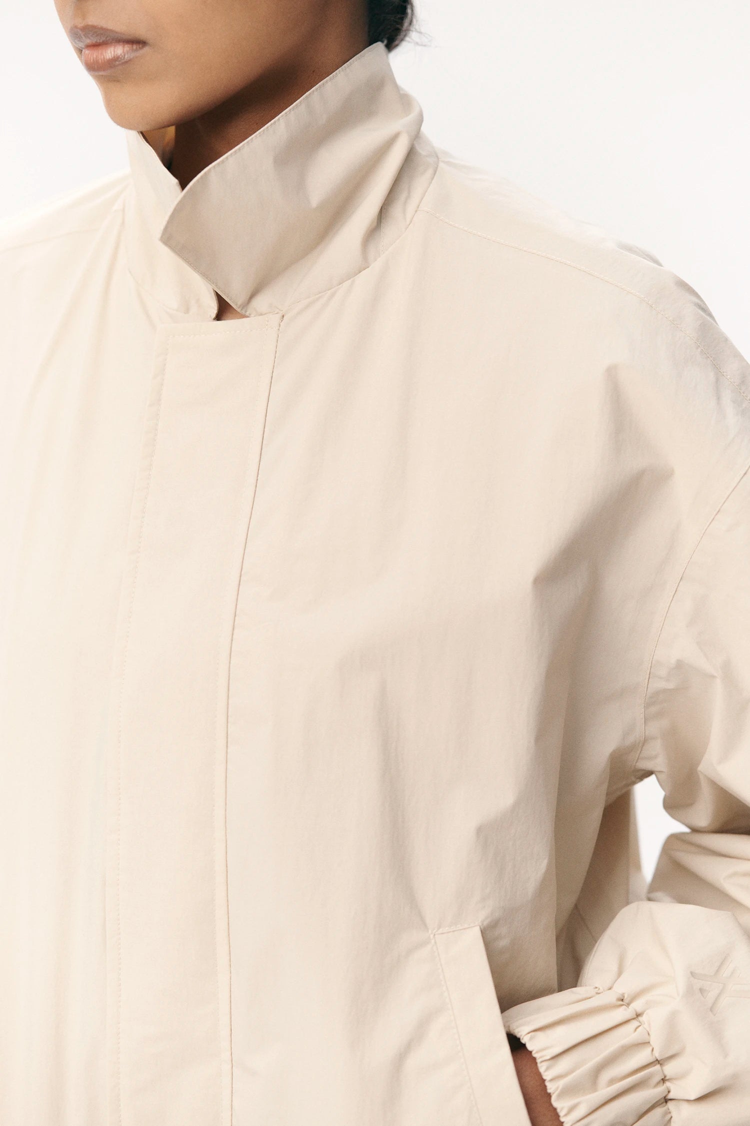 Close-up of model wearing Short Tracker WM Nylon Beige Jacket, showcasing its lightweight design and soft touch fabric.