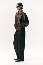 Short Tracker WM Dark Chocolate Jacket worn by a model, featuring faux leather and a relaxed fit.