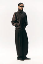 Short Tracker WM Dark Chocolate Jacket worn by a model, highlighting its stylish design and faux leather material.