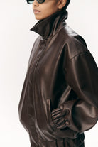 Short Tracker WM Dark Chocolate Jacket on a model, showcasing faux leather and stylish design.
