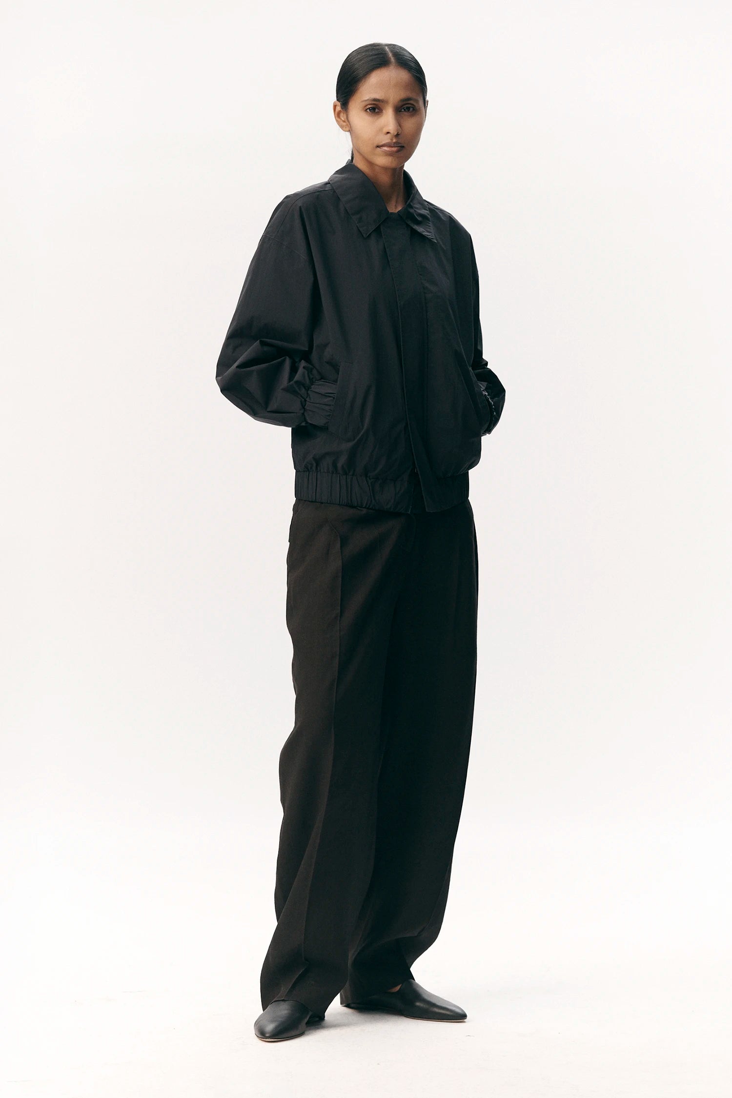 Short Tracker WM Nylon Navy Jacket modeled by a woman, featuring a relaxed fit, elastic waistband, and soft touch nylon material.