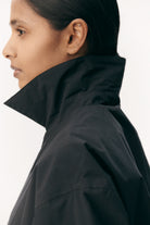 Short Tracker WM Nylon Navy Jacket worn with high collar showcasing a sleek, stylish look.