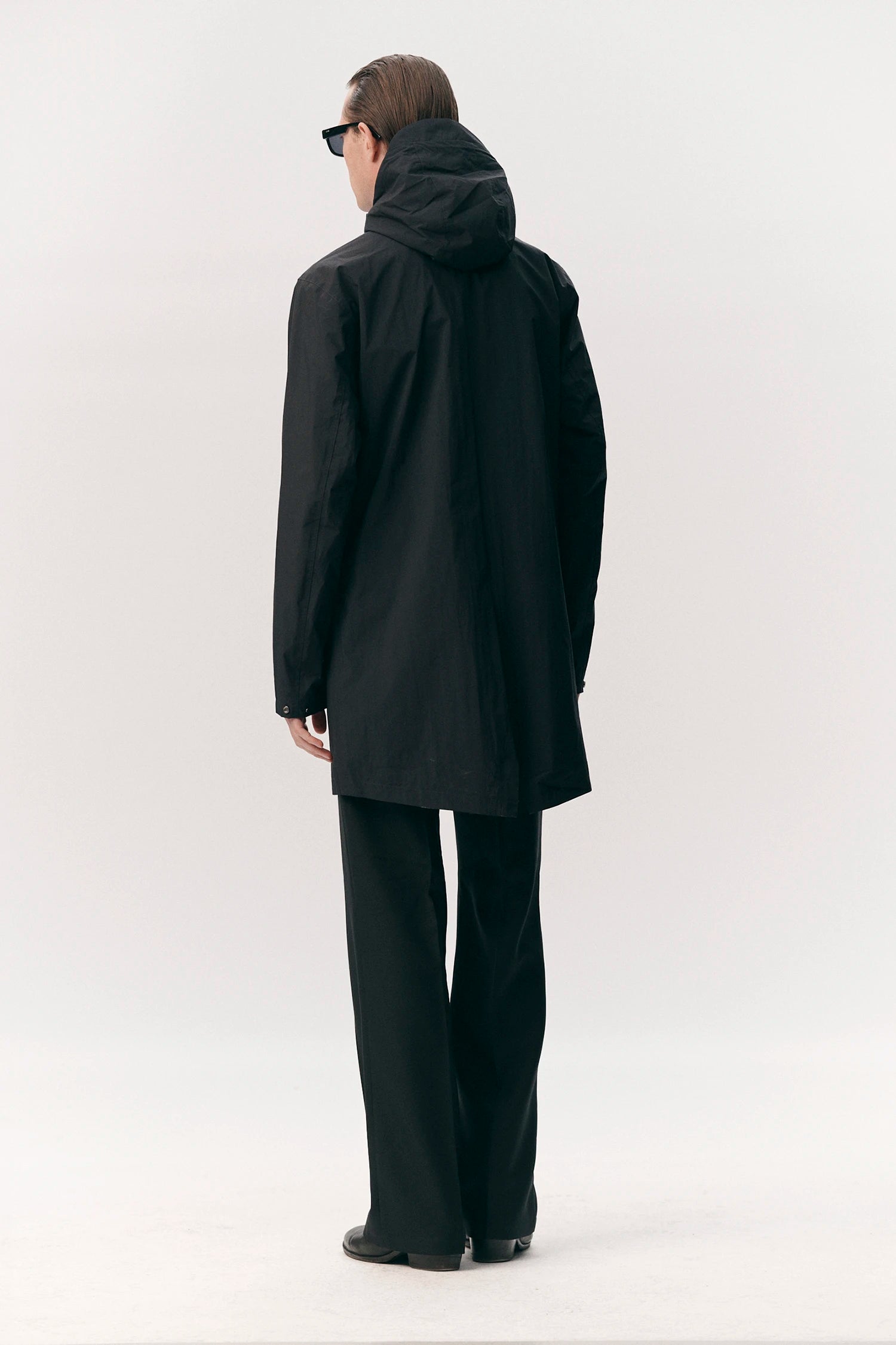 Model wearing the Terror Weather Nylon Navy Coat, showcasing the back view with adjustable hood and lightweight design.