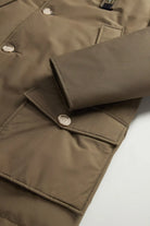 Arctic Parka Dark Green Coat featuring a close-up view of the durable fabric and button details.