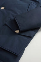 Close-up of Arctic Parka Melton Blue Coat showcasing buttons and patch pockets on navy fabric.