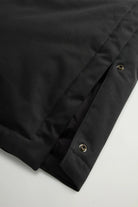 Detail view of the Best Cotton Faux Fur Parka Black Coat showing side splits with snap buttons.