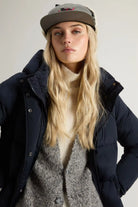 Model wearing a Kelly Jacket Melton Blue Coat with a cozy sweater and cap, showcasing winter style.