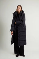 Kelly Long Parka Black Coat modeled by a woman, showcasing its premium down fill and stylish design.