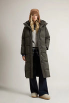 Woman wearing Kelly Long Parka Dark Green Coat with a cozy hat, showcasing premium down fill and stylish design.