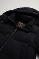 Madison Jacket Black Coat featuring Woolrich logo, stand-up collar, and removable hood in premium down fill.